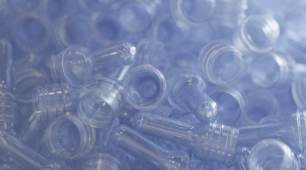 A close up of numerous clear plastic bottle caps scattered together, showcasing their transparent design and varying shapes 